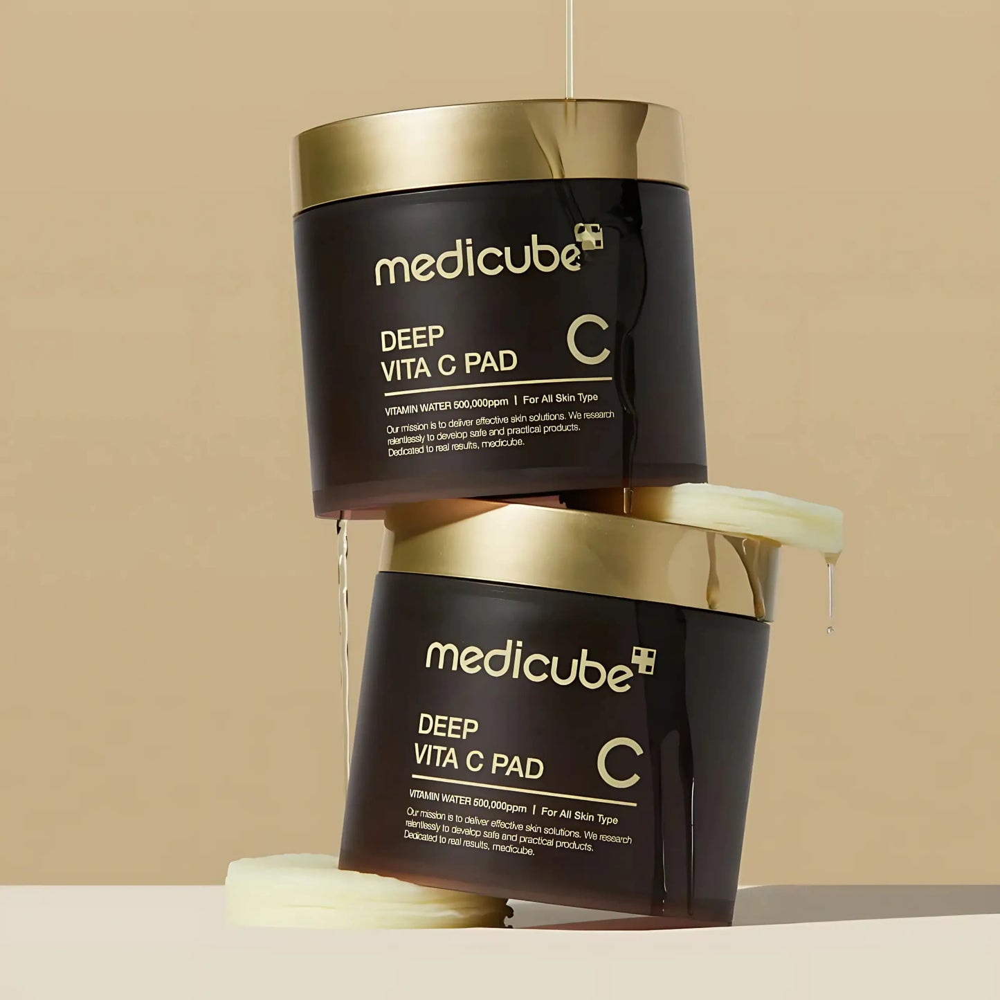 Dois frascos empilhados do Deep Vita C Pad da Medicube com líquido a escorrer, discos embebidos em vitamina C e niacinamida para pele luminosa – skincare k-beauty Portugal e cosmética coreana