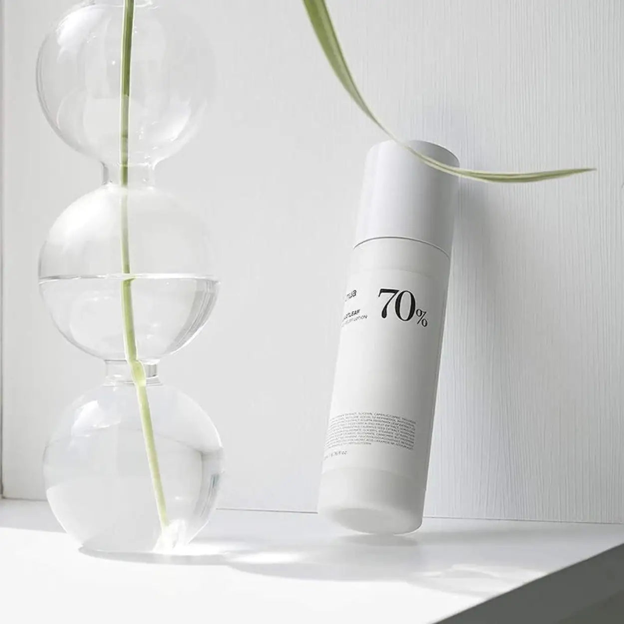 ANUA Heartleaf 70% Daily Relief Lotion ao lado de folhas verdes – loção hidratante de textura fluida, rica em extrato de heartleaf para pele com vermelhidão, cosmética coreana, skincare k-beauty Portugal