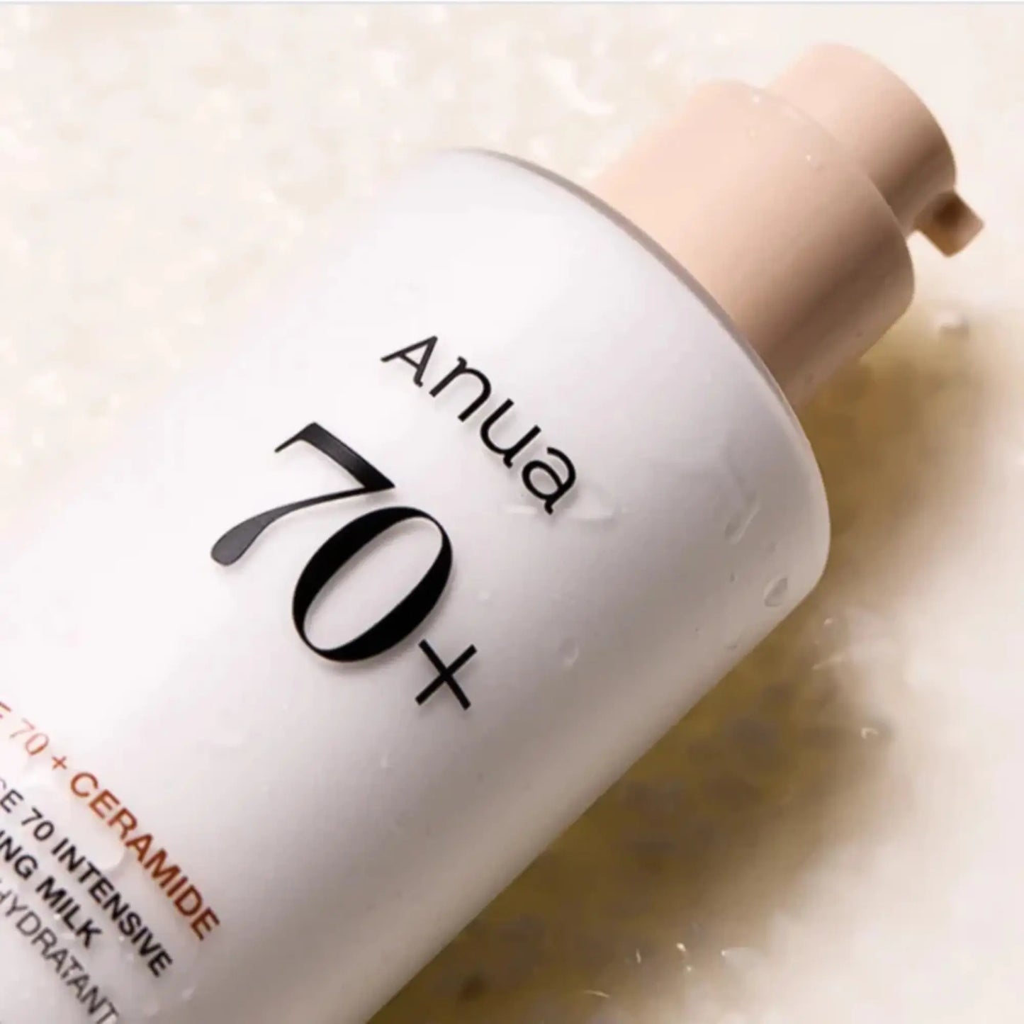 Anua Rice 70 Intensive Moisturizing Milk 150ml, loção coreana hidratante de arroz que reforça a barreira cutânea e ilumina, close-up da parte superior do frasco inclinado sobre fundo bege, cosmética coreana skincare k-beauty Portugal.