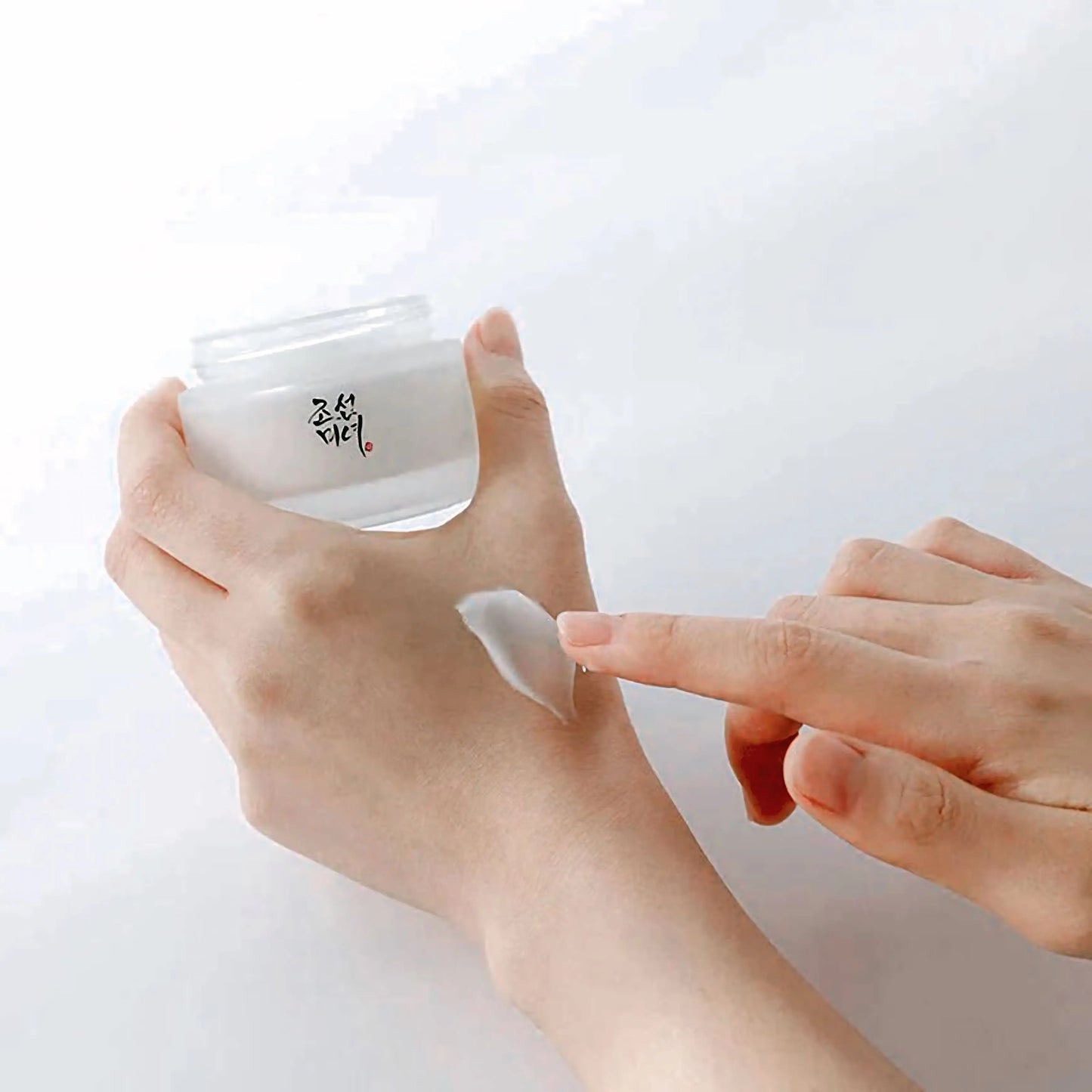Aplicação da Beauty of Joseon Dynasty Cream no rosto com os dedos – creme hidratante coreano para reparar e suavizar a pele, com ginseng e arroz, cosmética coreana, skincare k-beauty Portugal