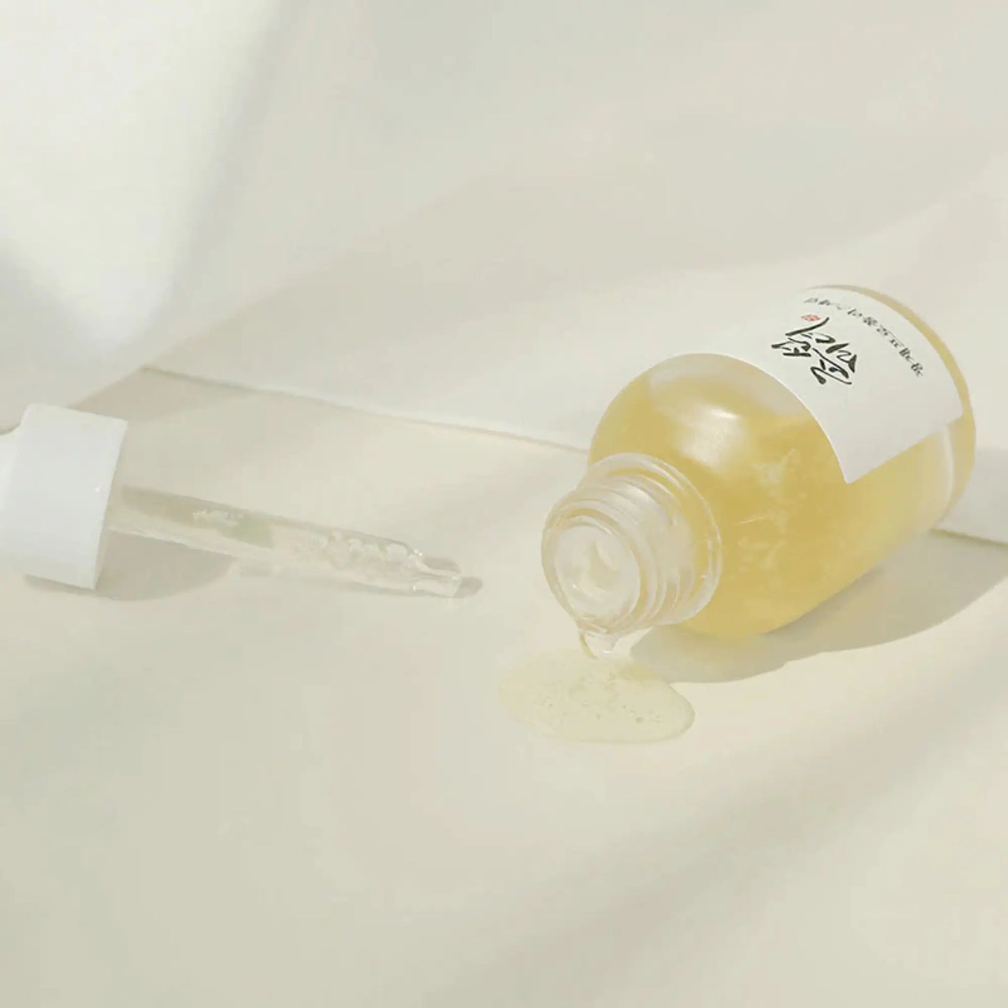 Beauty of Joseon Glow Serum Propolis + Niacinamide 30ml, sérum coreano com própolis calmante e niacinamida para luminosidade e poros refinados, frasco deitado sobre tecido branco com conta-gotas ao lado, cosmética coreana skincare k-beauty Portugal.