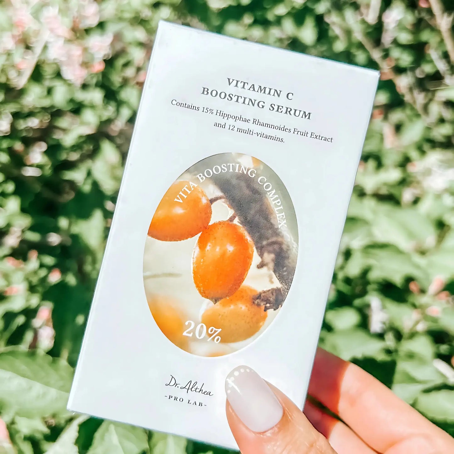 Dr. Althea Vitamin C Boosting Serum – frasco apresentado com a caixa do produto ao ar livre, ideal para quem procura um cuidado diário com vitamina C para pele radiante, cosmética coreana e skincare k-beauty Portugal