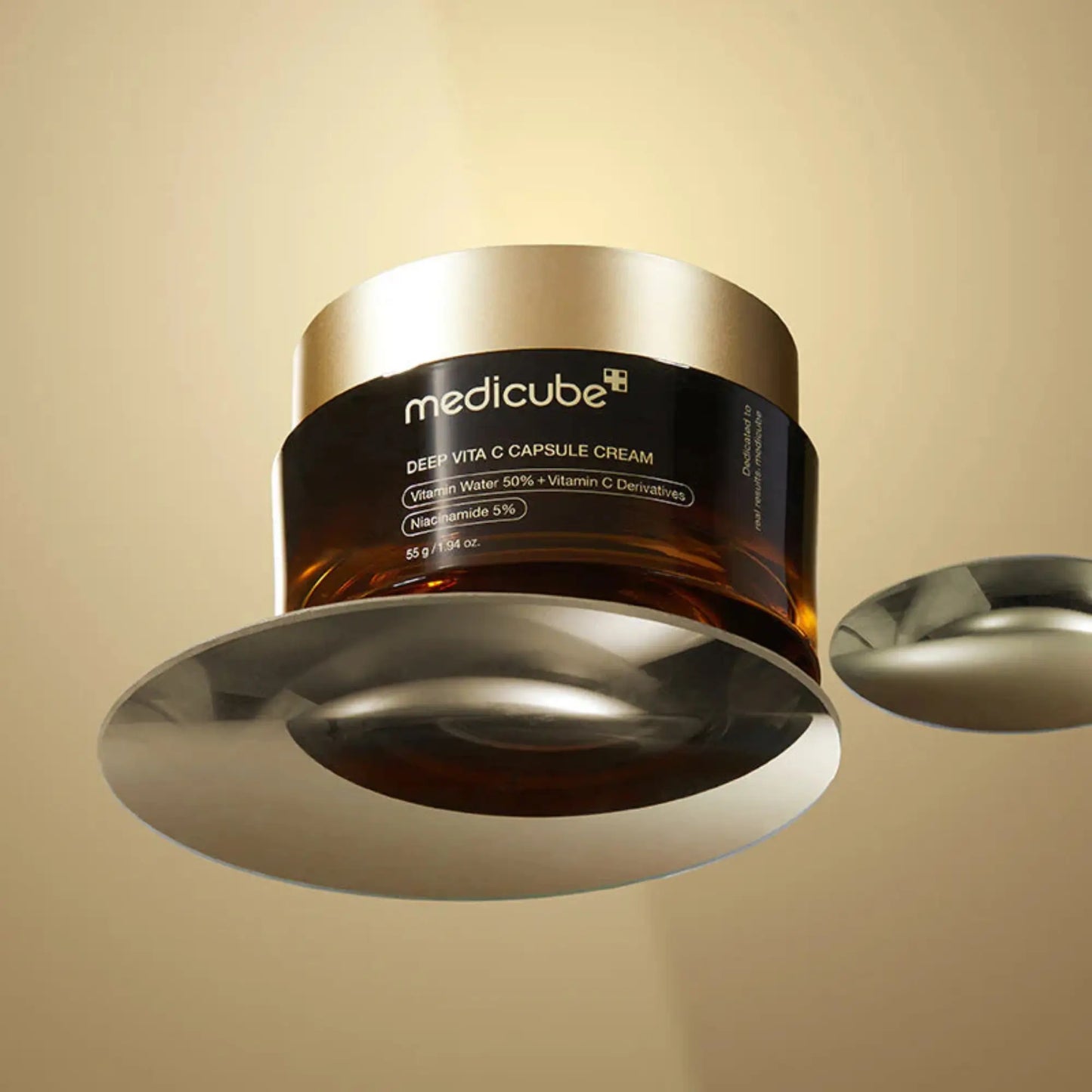 Medicube Deep Vita C Capsule Cream 55g, creme coreano antioxidante com vitamina C encapsulada, promove luminosidade e vitalidade, frasco aberto com tampa ao lado e colher dourada sobre fundo dourado, cosmética coreana skincare k-beauty Portugal.
