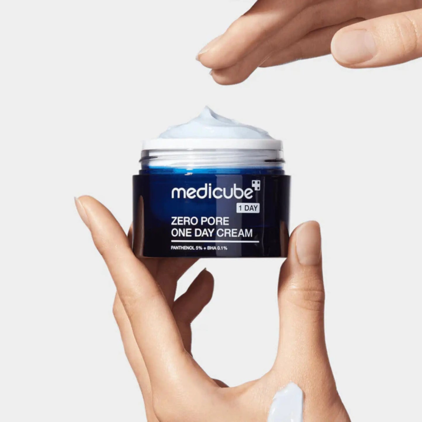 Medicube Zero Pore One Day Cream 50ml, creme facial coreano com textura leve e rápida absorção, hidrata, controla oleosidade e melhora elasticidade, mão a segurar frasco aberto sobre fundo branco, cosmética coreana skincare k-beauty Portugal.