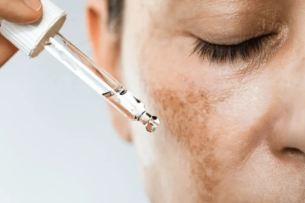 Aplicação de sérum com pipeta no rosto — fórmula coreana com ingredientes ativos como vitamina C, ácido hialurónico ou retinol, ideal para hidratar, iluminar e reduzir manchas. Passo concentrado na rotina de skincare coreano para rosto – cosmética coreana e skincare k-beauty Portugal.