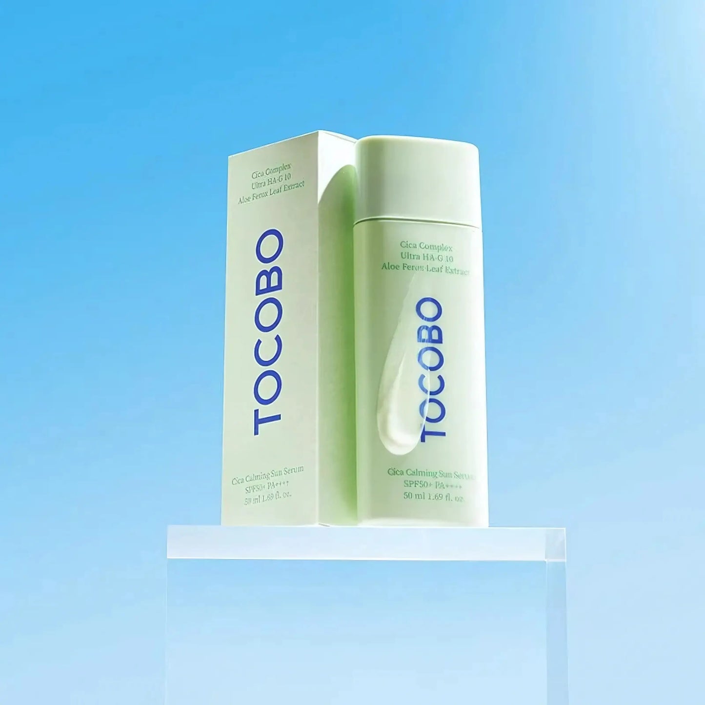 TOCOBO Cica Calming Sun Serum – duas embalagens sobre base elevada em fundo azul claro, representando a leveza, frescura e dupla função de proteção e cuidado