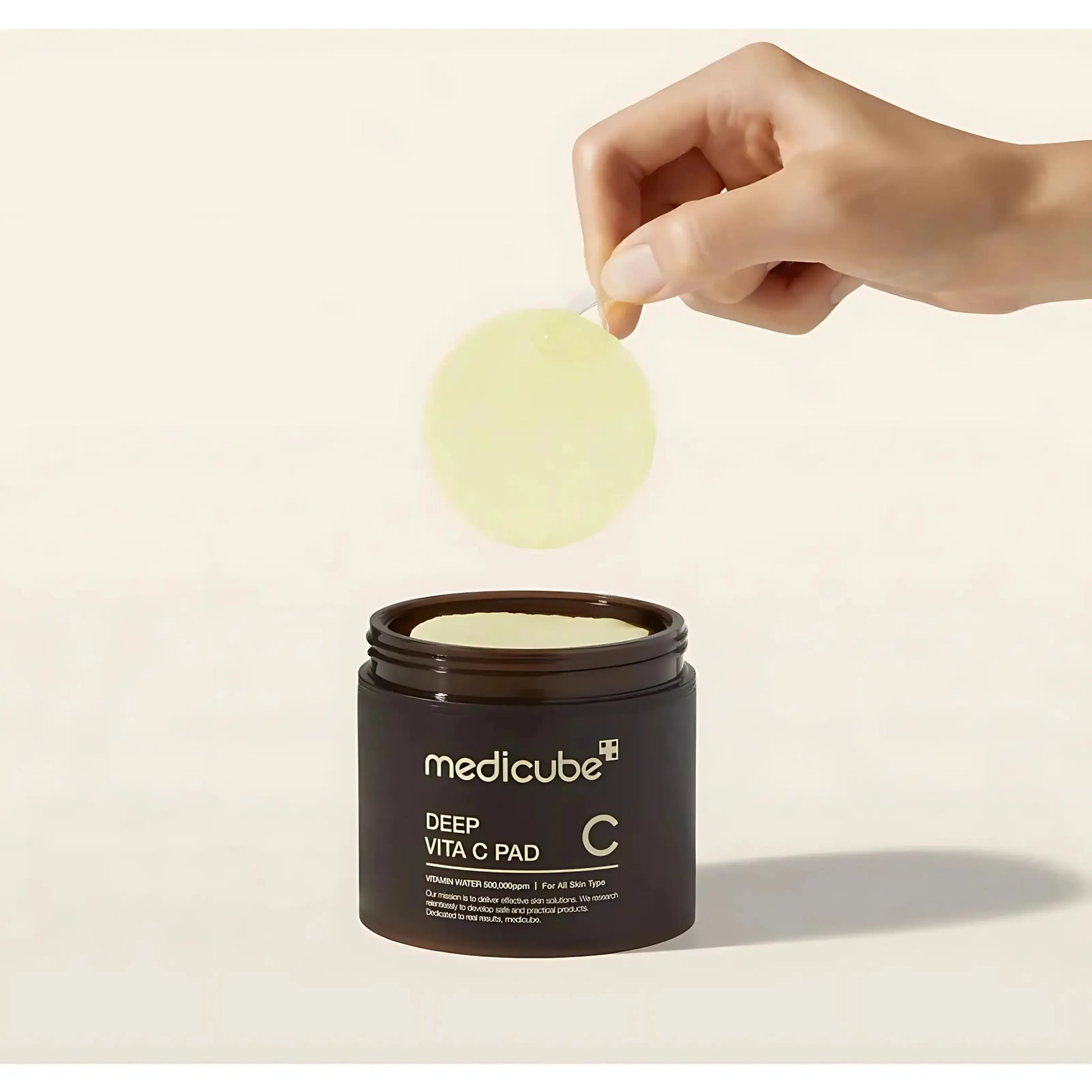 Mão a retirar um disco do Deep Vita C Pad da Medicube, com fórmula rica em vitamina C e niacinamida para luminosidade da pele – cosmética coreana e skincare k-beauty Portugal