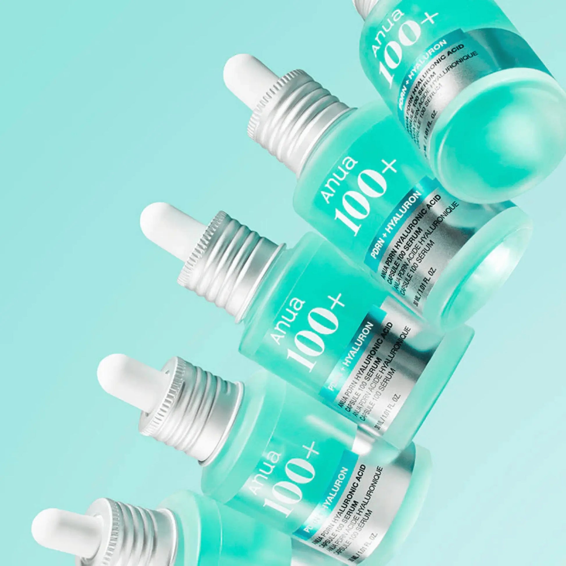 Anua PDRN Hyaluronic Acid Capsule 100 Serum 30ml, sérum coreano intensivo com ácido hialurónico e PDRN que reforça hidratação e elasticidade, vários frascos empilhados em fundo azul claro, cosmética coreana skincare k-beauty Portugal.