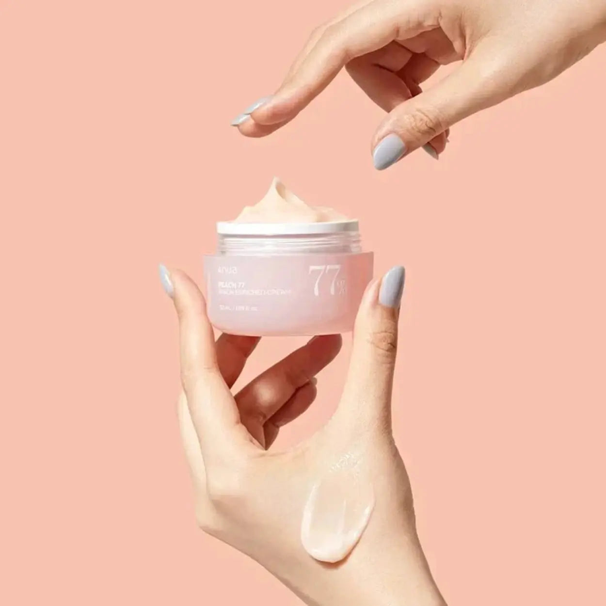 ANUA Peach 77% Niacin Enriched Cream na mão com tampa aberta – creme coreano iluminador e suavizante com textura cremosa, ideal para pele sensível, cosmética coreana, skincare k-beauty Portugal