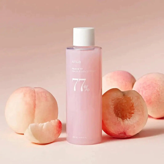 ANUA Peach 77% Niacin Essence Toner com pêssegos ao redor em fundo rosa – tónico coreano iluminador com niacinamida e extrato de pêssego, ideal para uniformizar o tom da pele, cosmética coreana, skincare k-beauty Portugal