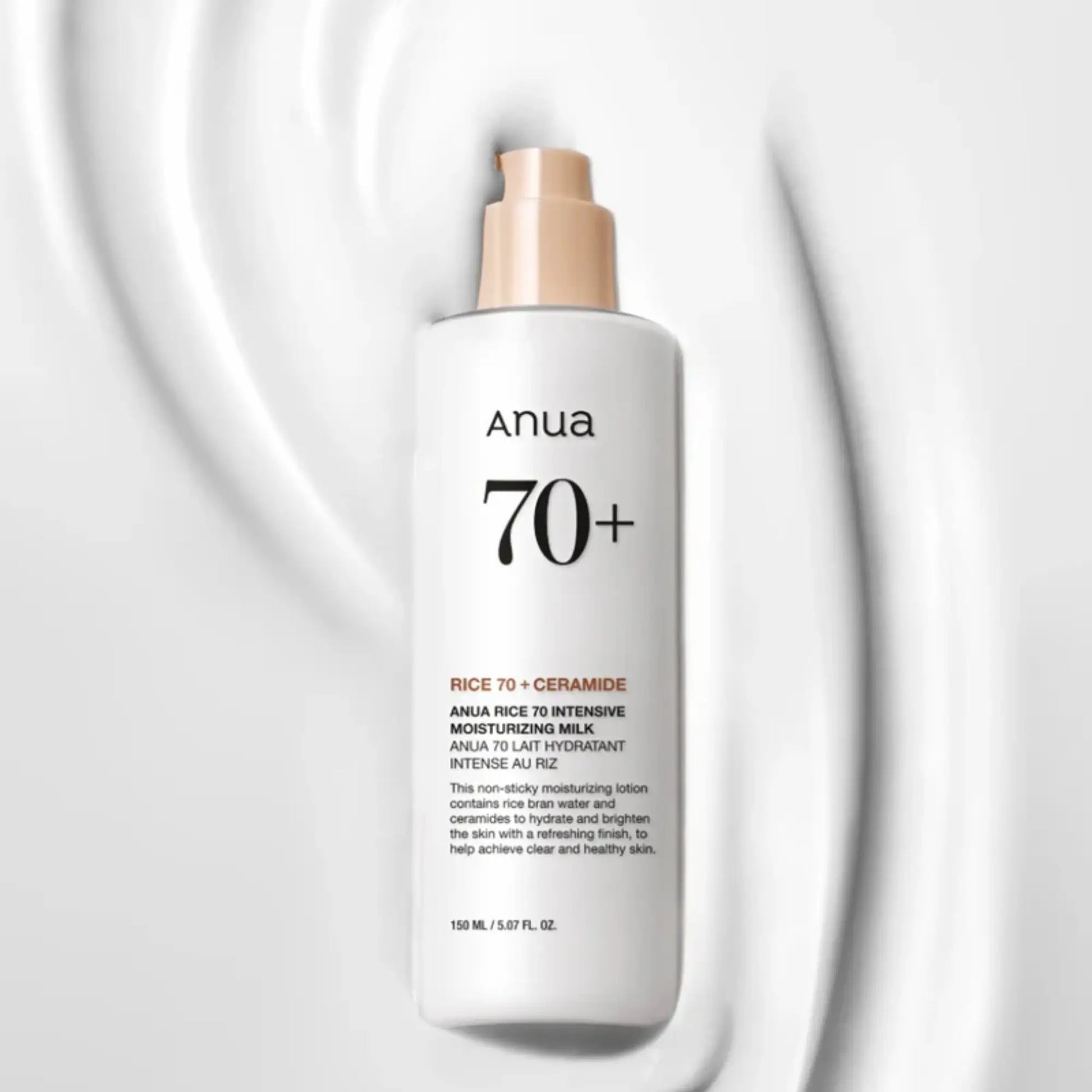 Anua Rice 70 Intensive Moisturizing Milk 150ml, loção hidratante coreana de arroz para pele nutrida, suave e luminosa, frasco em pé com textura branca espalhada ao lado sobre fundo branco, cosmética coreana skincare k-beauty Portugal.