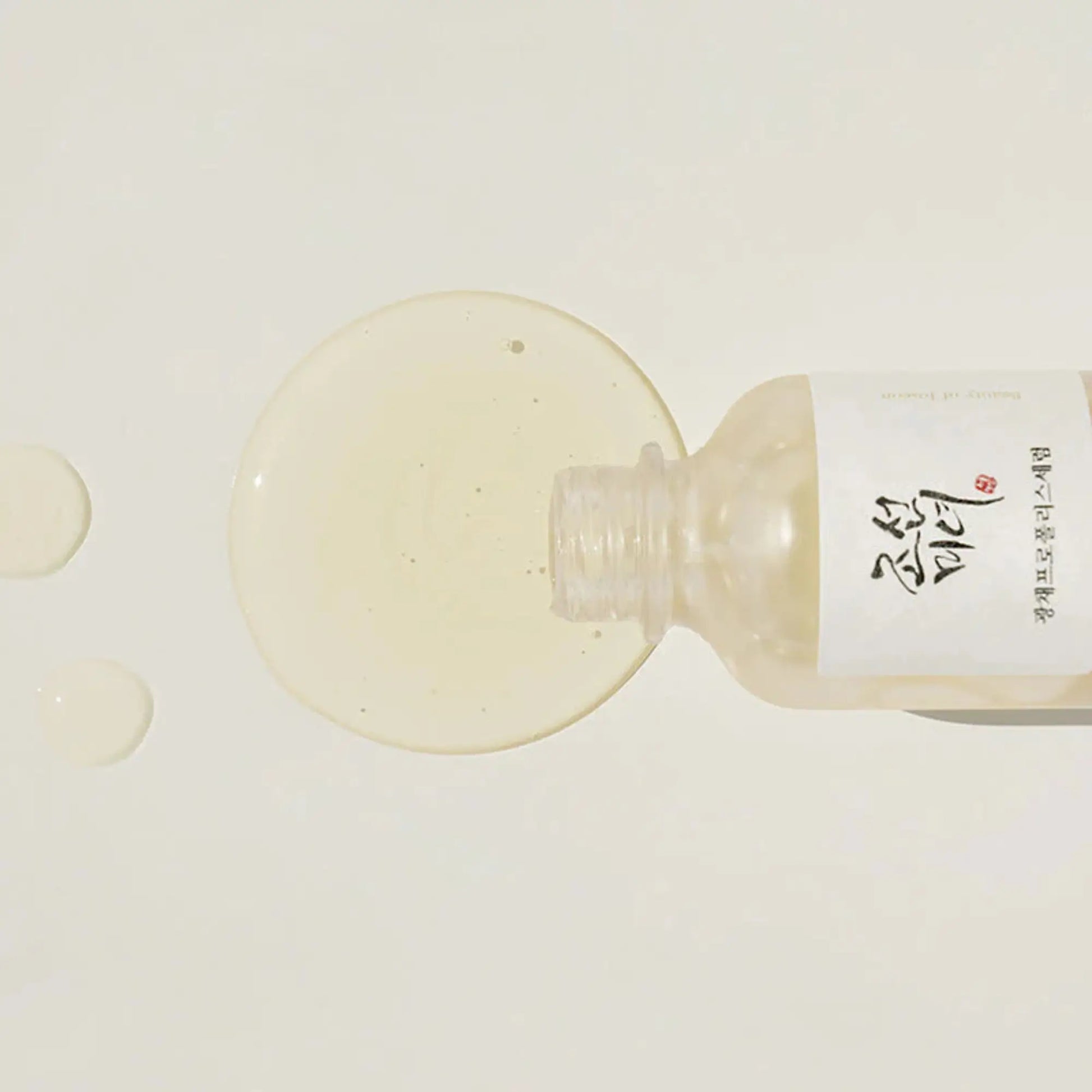 Beauty of Joseon Glow Serum Propolis + Niacinamide 30ml, sérum facial coreano iluminador que reduz imperfeições, hidrata e dá luminosidade, frasco deitado com conta-gotas e líquido dourado espalhado sobre fundo branco, cosmética coreana skincare k-beauty Portugal.