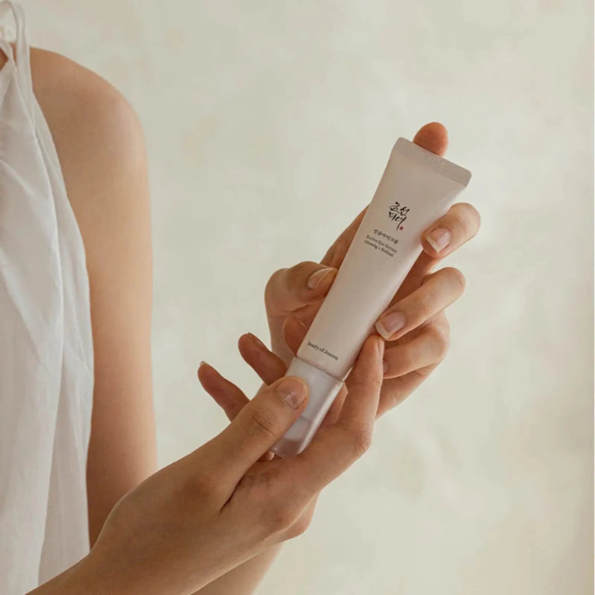 Revive Eye Serum: Ginseng + Retinal da Beauty of Joseon segurado nas mãos em fundo claro