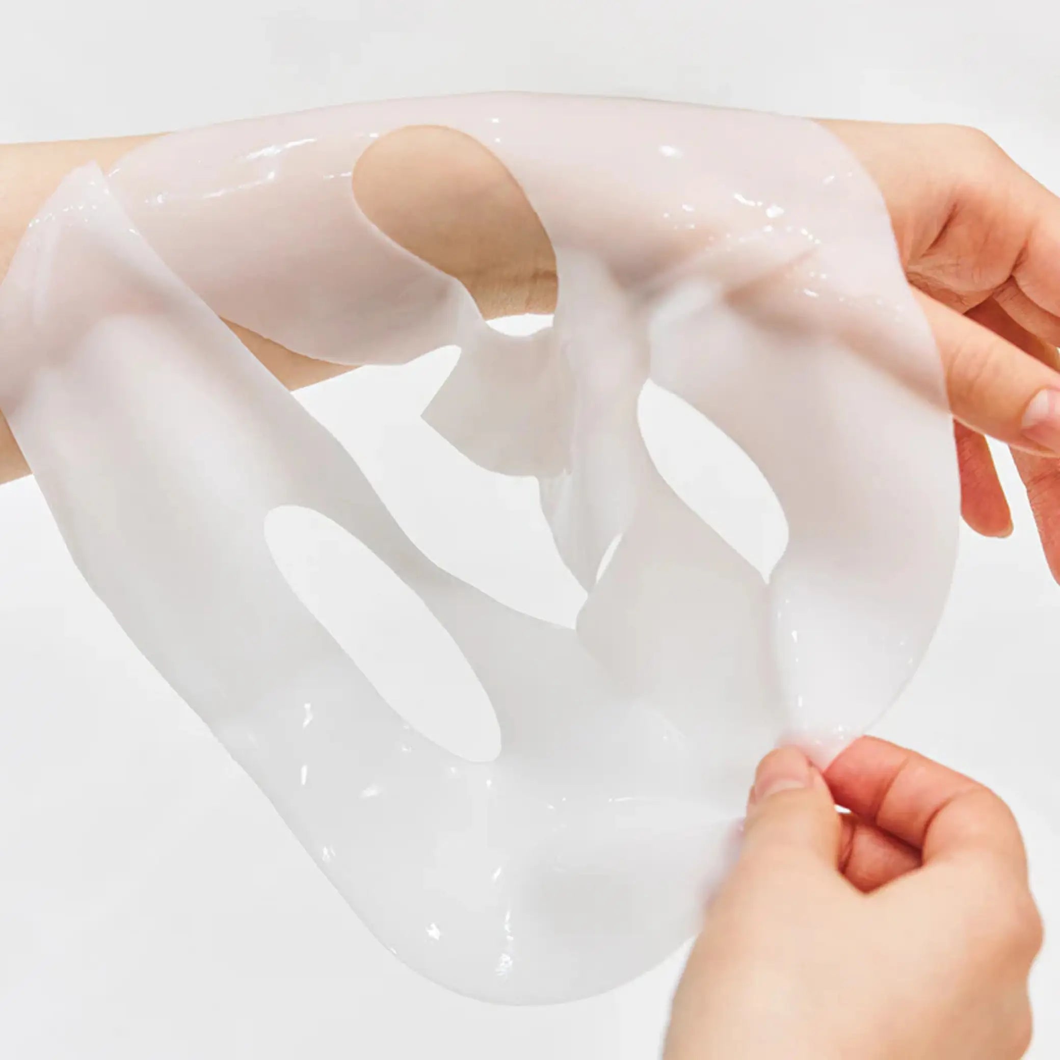 Bio-Collagen Real Deep Mask da Biodance folha da máscara aberta e segurada nas mãos