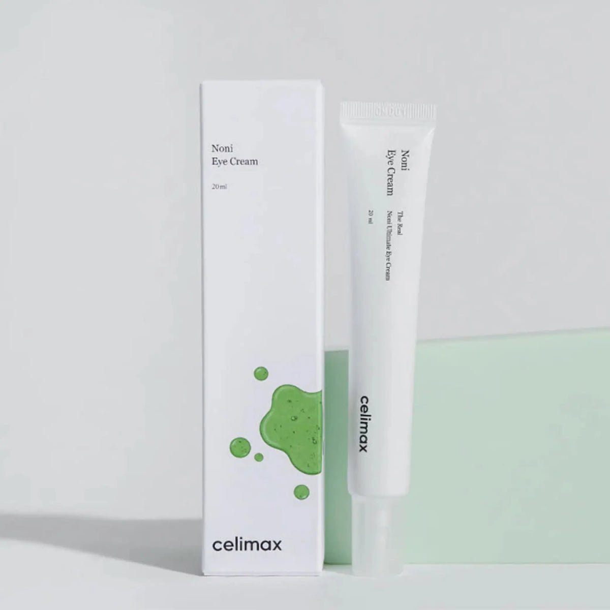 The Real Noni Ultimate Eye Cream da Celimax com caixa e tubo em fundo cinza