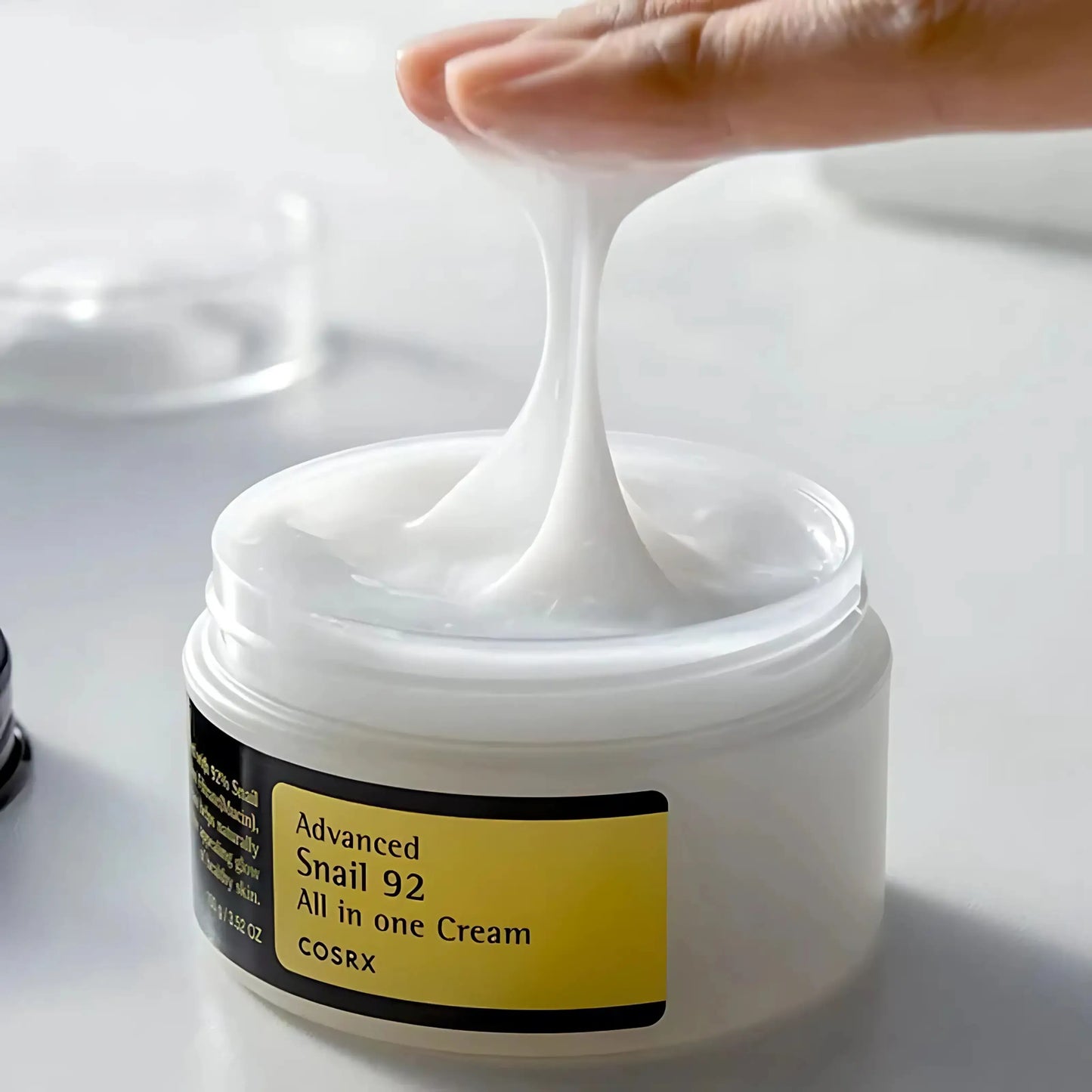 COSRX Advanced Snail 92 All In One Cream com textura cremosa visível – regenerador facial com 92% de mucina de caracol, ideal para pele sensível e desidratada, cosmética coreana