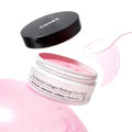 The Peptide Collagen Hydrogel Eye Patch da COSRX em frasco aberto com patches rosa e salpicos de essencia em fundo branco