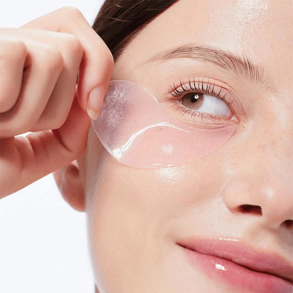 The Peptide Collagen Hydrogel Eye Patch da COSRX modelo a retirar patch transparente rosa da zona do olho
