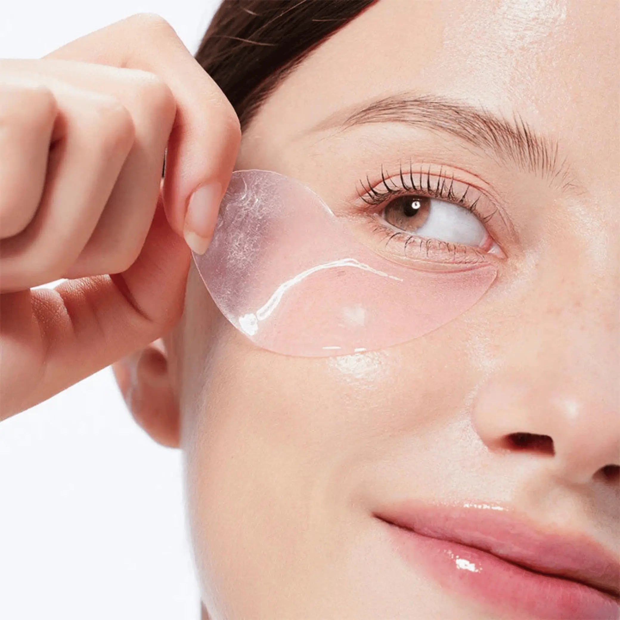 The Peptide Collagen Hydrogel Eye Patch da COSRX modelo a retirar patch transparente rosa da zona do olho