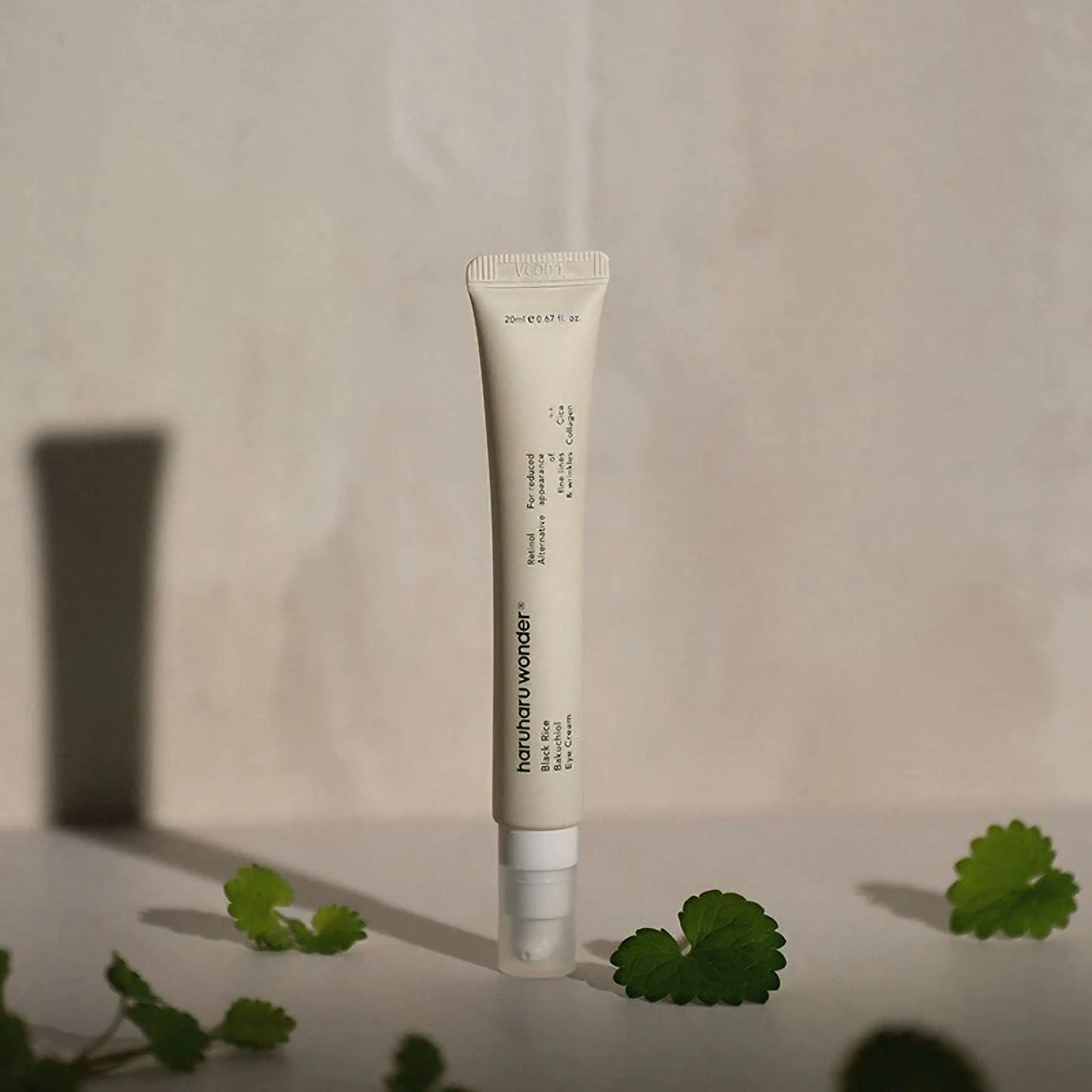 Haruharu Wonder Black Rice Bakuchiol Eye Cream em pé com fundo suave e folhas de centella – creme de olhos coreano com arroz preto e bakuchiol, suaviza rugas e hidrata, ideal para olhos sensíveis, cosmética coreana, skincare k-beauty Portugal