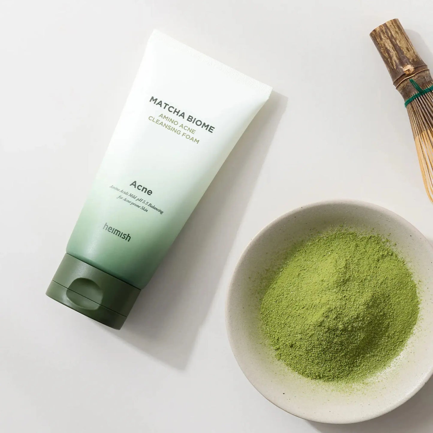 Heimish Matcha Biome Amino Acne Cleansing Foam 150g, espuma de limpeza facial coreana com matcha e aminoácidos que purificam poros, controlam oleosidade e acalmam pele sensível, frasco em pé com pó de matcha ao lado sobre fundo branco, cosmética coreana skincare k-beauty Portugal.