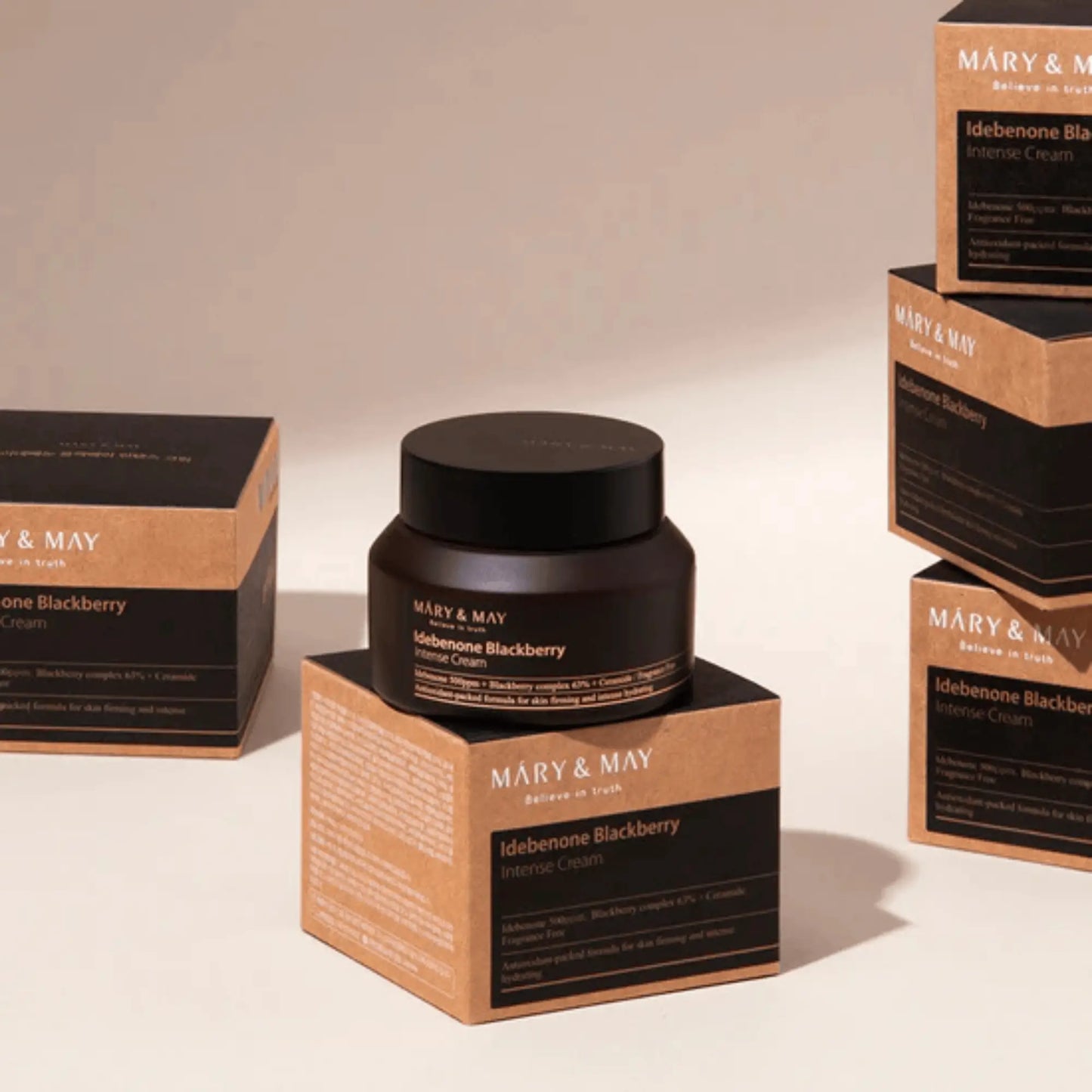 Mary & May Idebenone + Blackberry Complex Intensive Total Care Cream 70g, creme facial coreano antioxidante para hidratação e firmeza, frasco fechado em destaque sobre fundo bege claro com caixas atrás, cosmética coreana skincare k-beauty Portugal.
