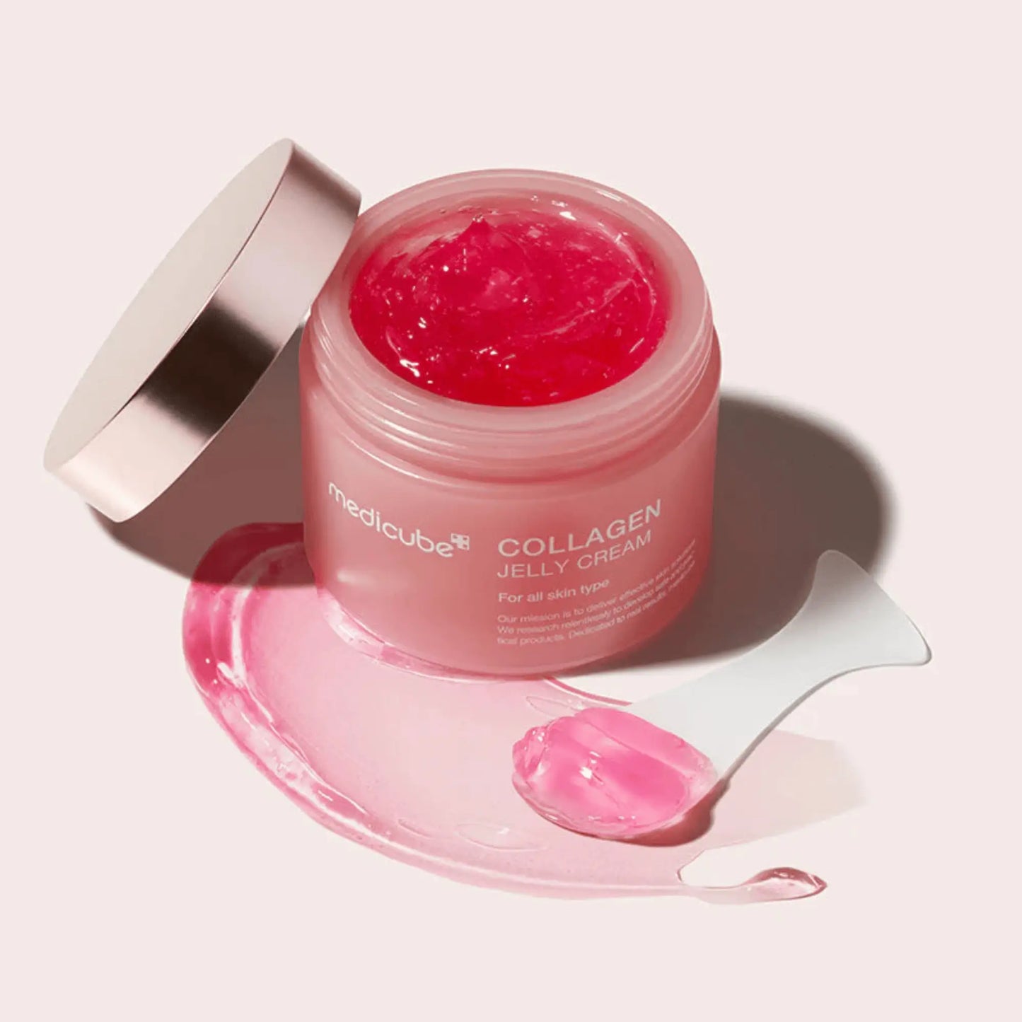Medicube Collagen Jelly Cream 110ml, creme facial coreano com colagénio em textura jelly refrescante, promove hidratação profunda e elasticidade, frasco aberto com textura jelly rosa espalhada em traço, fundo claro, cosmética coreana skincare k-beauty Portugal.