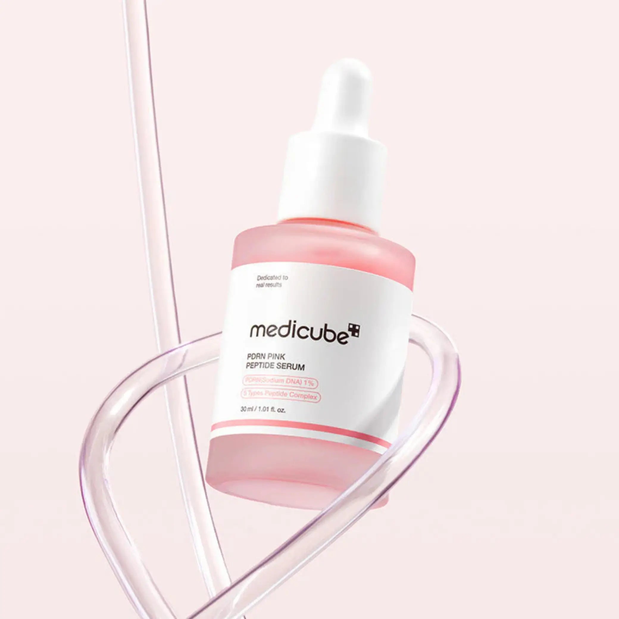 PDRN Pink Peptide Face Serum da medicube frasco com pipeta em fundo rosa
