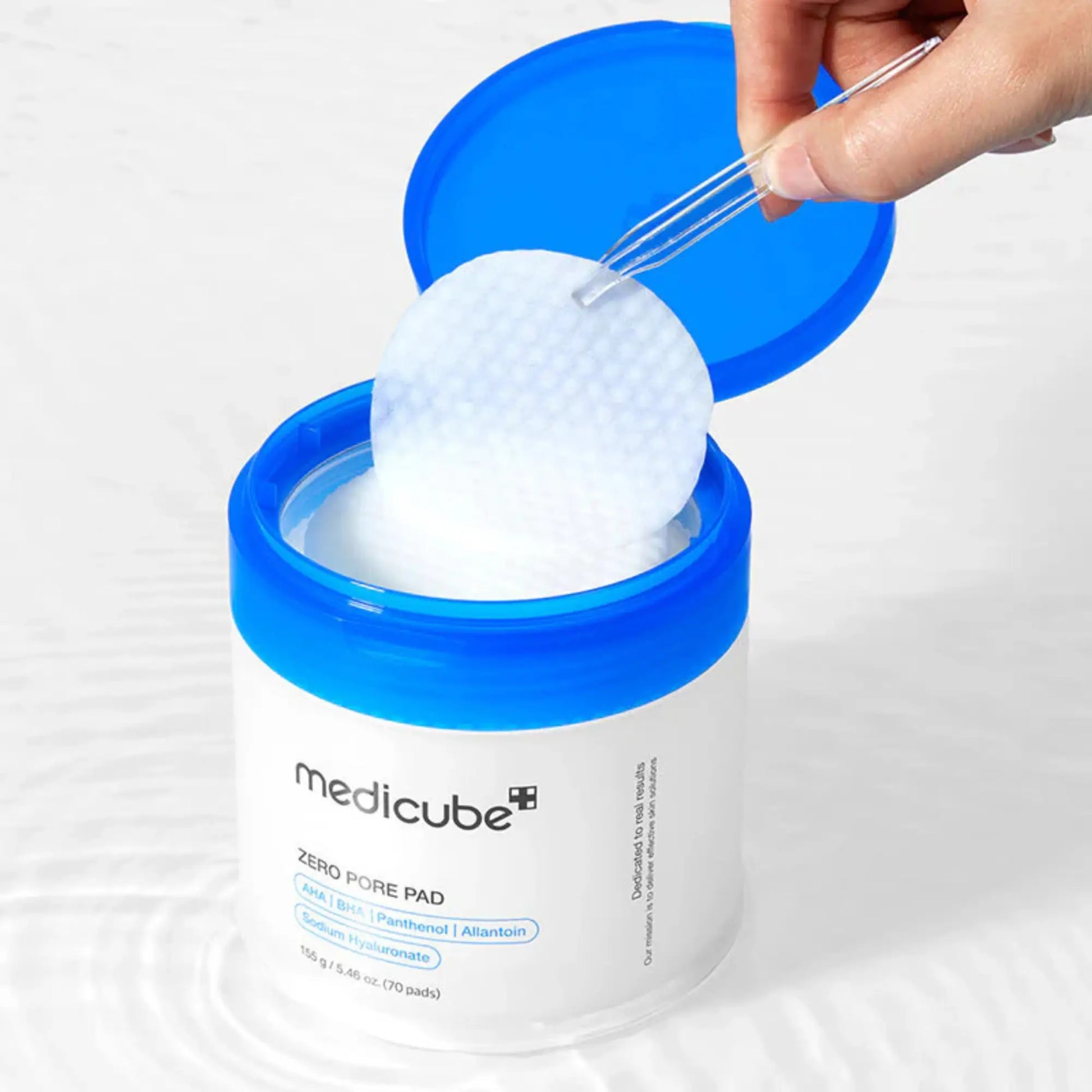 Medicube Zero Pore Pad 2.0 (70pcs), exfoliante facial coreano em discos com AHA, BHA e PHA, promove pele mais lisa, sem excesso de oleosidade e com poros minimizados, frasco aberto visto de cima com discos visíveis, fundo azul, cosmética coreana skincare k-beauty Portugal.