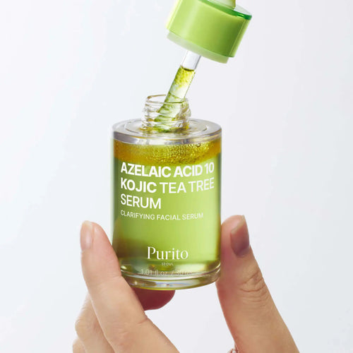 Azelaic Acid 10 Kojic Tea Tree Serum da Purito SEOUL em frasco aberto com pipeta e mão a segurar