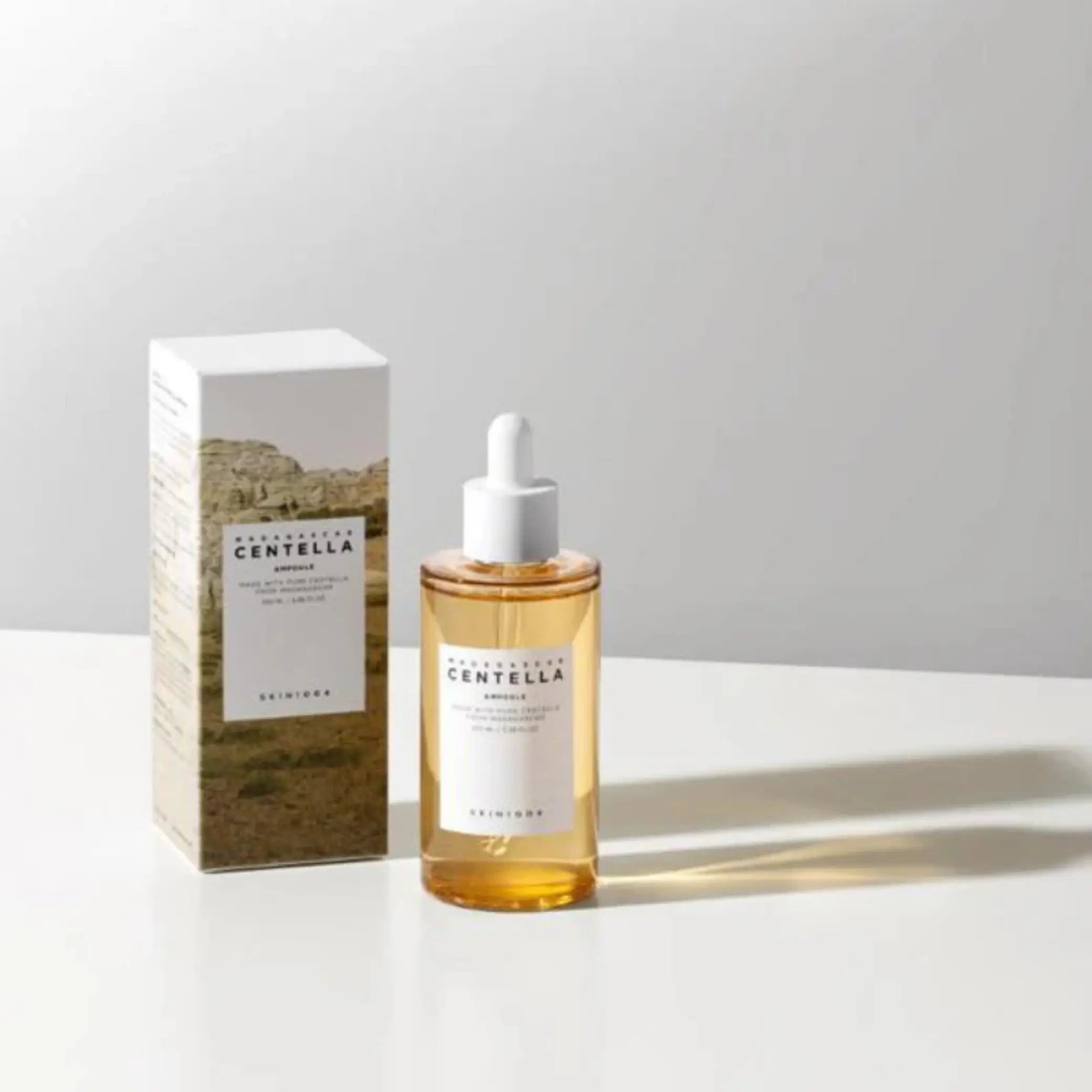 Madagascar Centella Ampoule da Skin1004 em frasco âmbar com pipeta ao lado da caixa em fundo branco