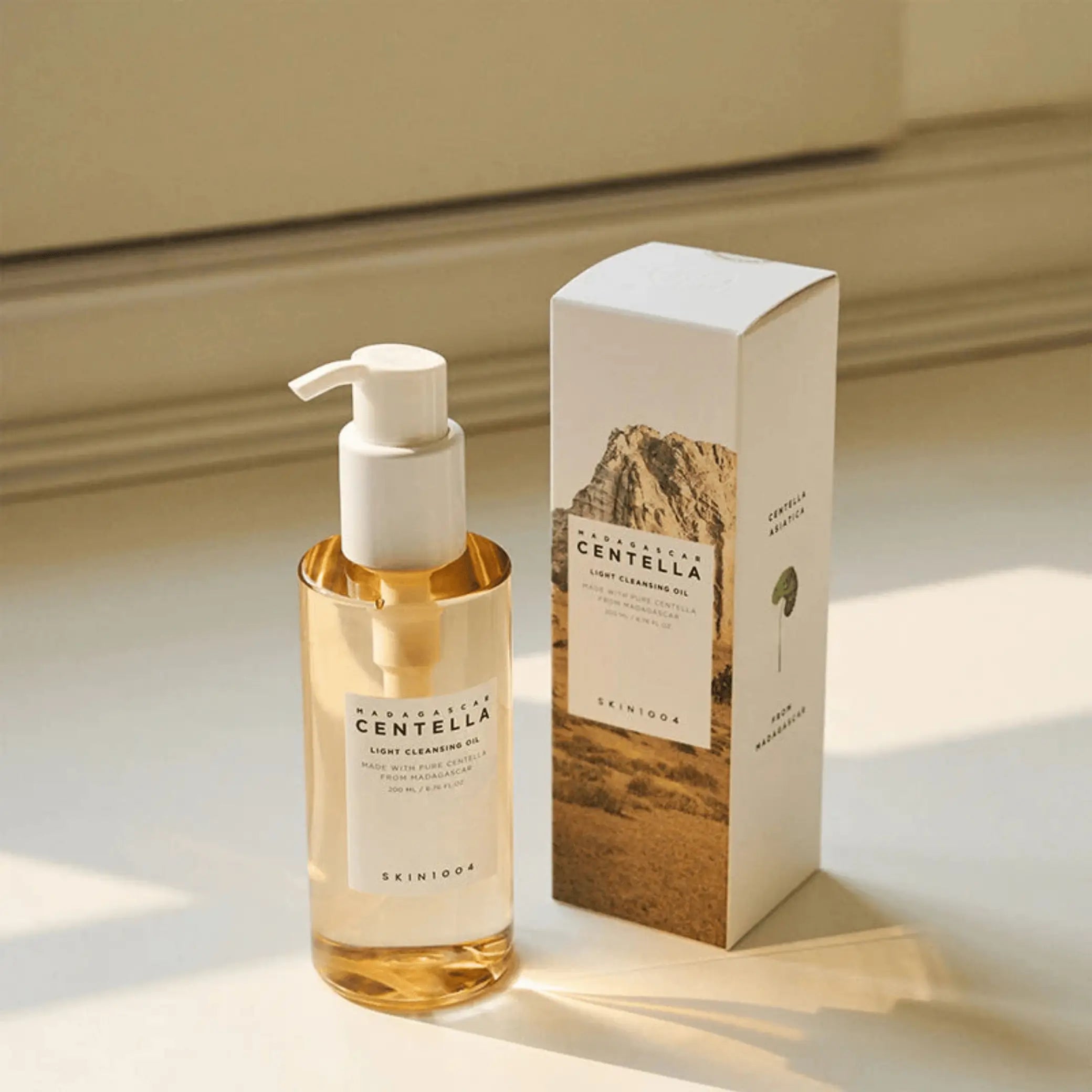 Madagascar Centella Light Cleansing Oil da Skin1004 em frasco com bomba ao lado da caixa com luz natural