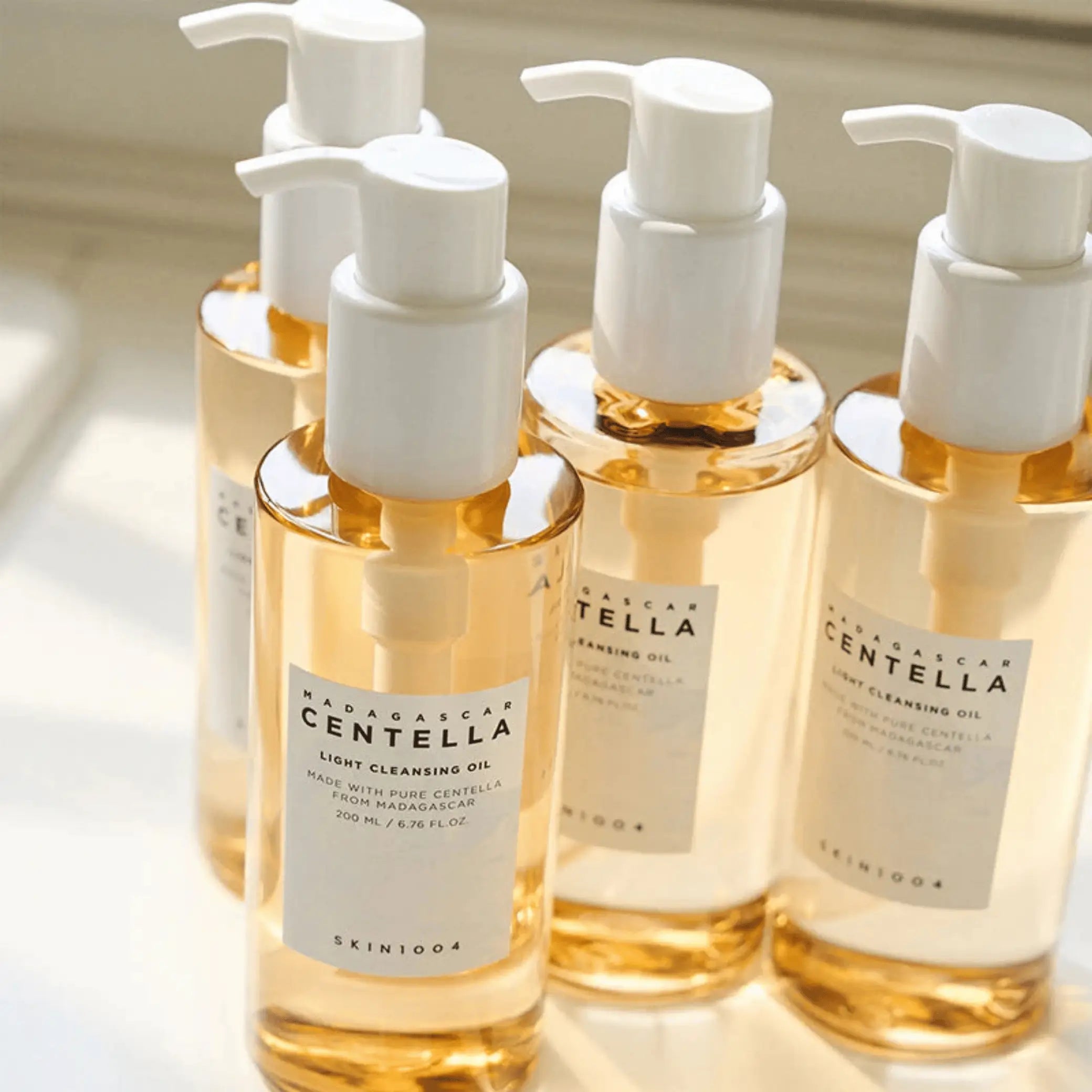Madagascar Centella Light Cleansing Oil da Skin1004 em vários frascos âmbar com bomba em close-up