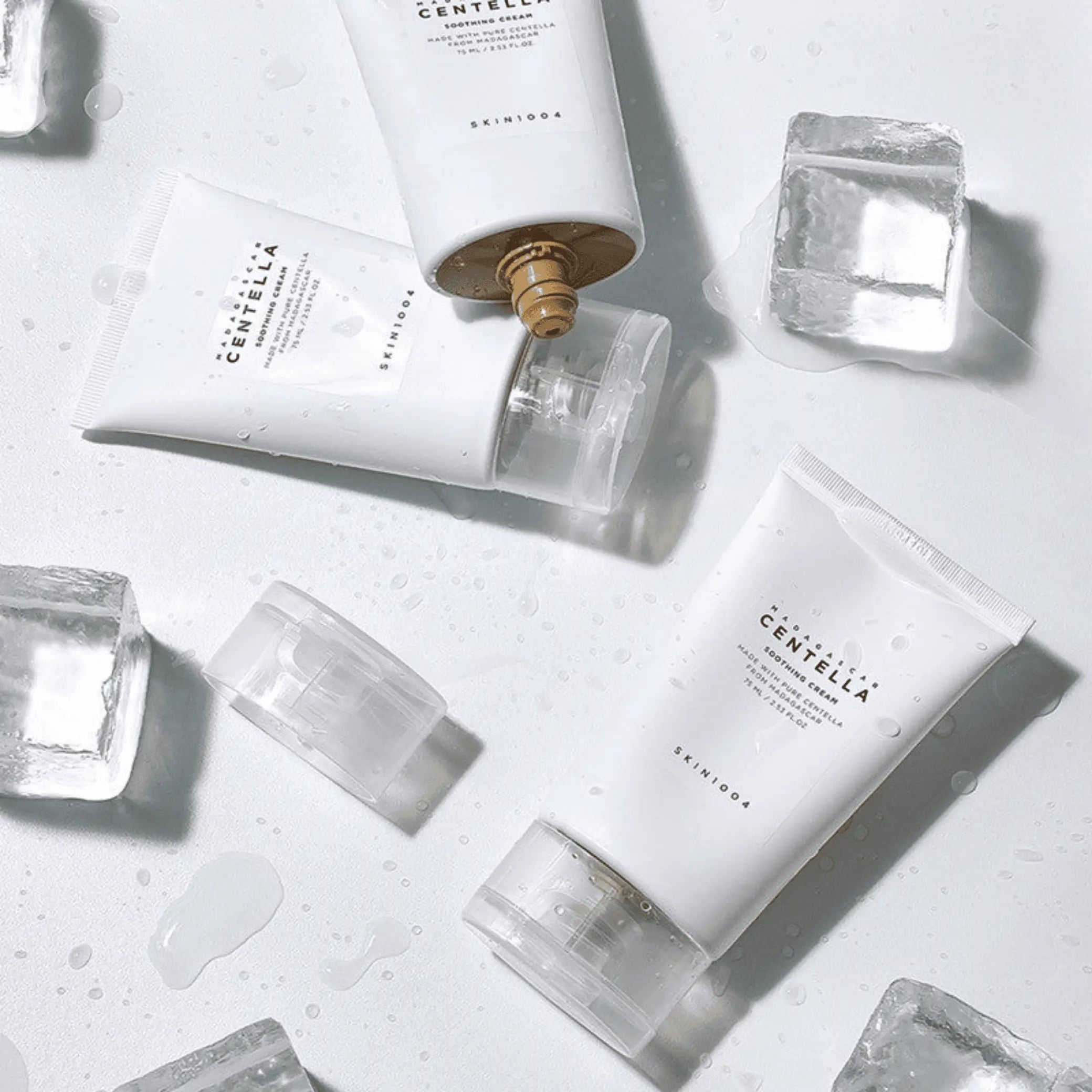 Madagascar Centella Soothing Cream da Skin1004 em duas bisnagss dispostas com cubos de gelo em redor