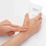 Madagascar Centella Soothing Cream da Skin1004 modelo a espalhar textura dourada no dorso da mão
