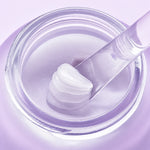 Pormenor da textura da TOCOBO Collagen Boosting Lip Mask num boião aberto, com bálsamo na espátula.